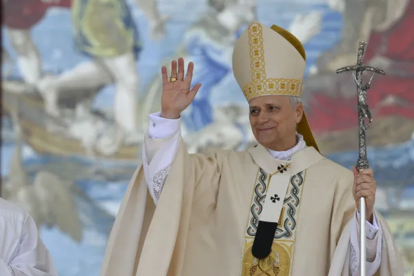 Pope Leo XIV waves during the inaugural Mass of his pontificate, held in St. Peter’s Square on May 18, 2025. He stands in front of a Flemish tapestry depicting the dialogue between Jesus and Peter after the miraculous catch of fish. / Credit: Vatican Media